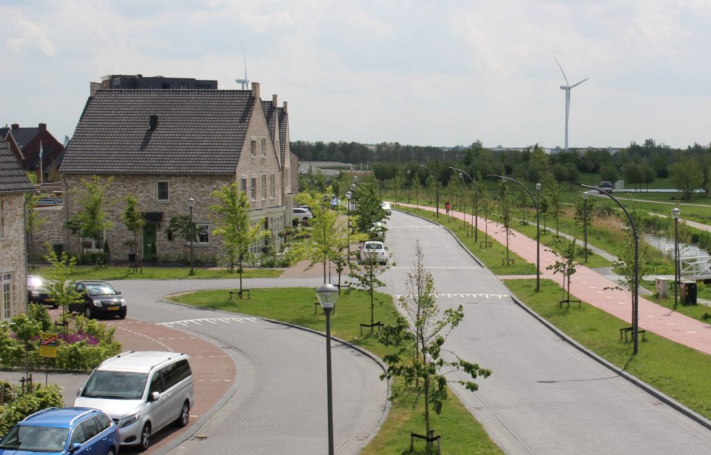 Nieuw gebouwde woningen in Park Triangel met wegen, nieuw aangelegd groen met boompjes en parkeerplaatsen met auto's